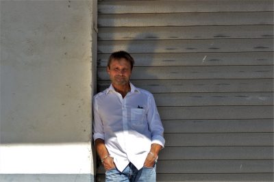 Armin Bösch lehnt an einer Mauer vor einem Rolltor