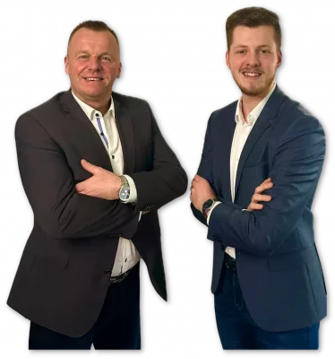 Foto von Marcus Colligs und Leon Merten, welche die Arme verschränken und Anzüge tragen. Sie schauen lächelnd in die Kamera
